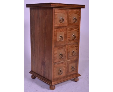 A contemporary 20th century hardwood inlaid pedestal merchants chest of drawers. Raised on bun feet with plinth having an upr