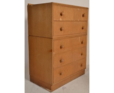 A Meredew 1960's retro vintage golden oak chest having a bank of 5 drawers each with conical button pull handles, all raise o