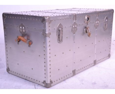 A large vintage metal covered travel trunk having brown leather carrying handles with blue lined interior. Measures 55 cm hig