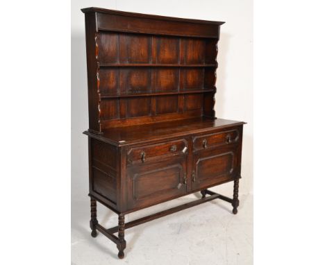 A 1920's oak Jacobean revival geometric block fronted sideboard / dresser. Raised on bobbin turned legs united by stretchers 