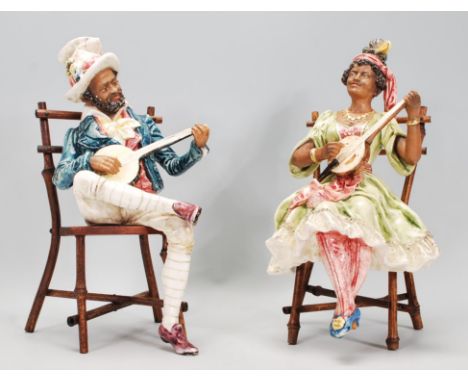 A pair of 20th Century ceramic continental creole band figures seated upon bamboo chairs playing banjos. Measures 30 cm tall.
