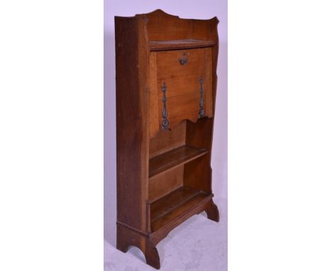 A VIctorian 19th century Arts &amp; Crafts oak student bureau having stepped feet with open bookcase beneath a fall front bur