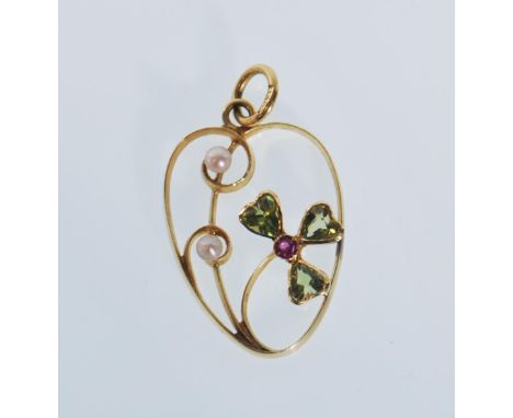 A 20th Century stamped 15ct gold open work pendant set with seed pearls, peridots and a ruby within a shamrock design. Weight