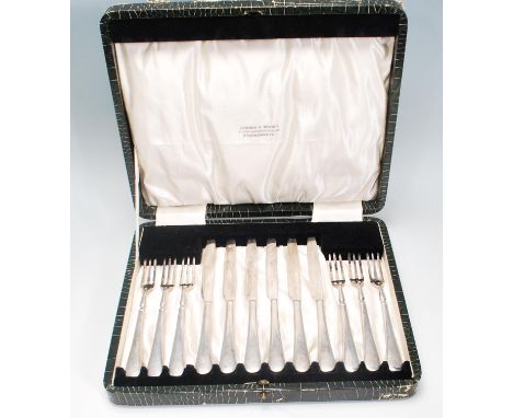 A vintage silver plated cake knife and fork set consisting of six knives and forks set within its original faux crocodile ski