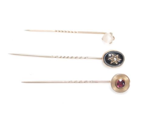 A group of three Victorian stick pins to include a pin set with a round cut amethyst in an engine turned mount, a banded agat