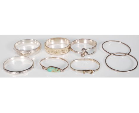 A collection of silver bangles to include a hallmarked sterling silver bangle with etched foliate design hallmarked London, a