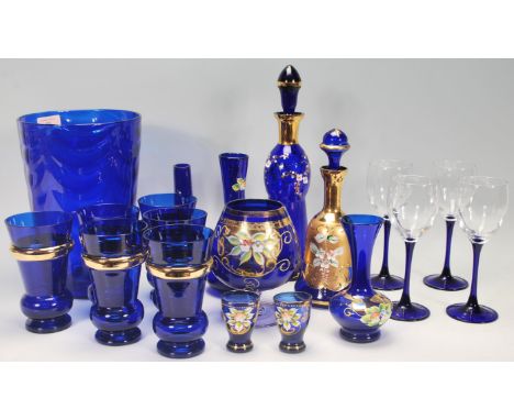 A good collection of 20th Century blue glassware to include a large blue glass vase, decanters, vases, a set of six drinking 