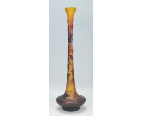 A Galle Tip Art Nouveau style vase having a bulbous form base with a tapering neck, a yellow ground with raised pink floral d