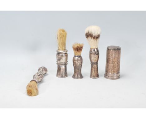 A good group of four vintage 20th Century silver handled shaving brushes of varying sizes and shapes to include a repousse fl