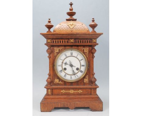 A Victorian 19th century oak mantel / bracket clock with oak case having pediment top with inset brass movement. The dial mar