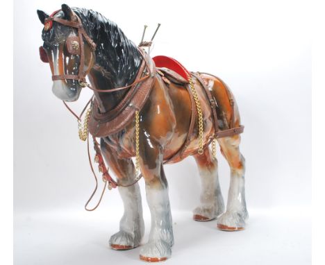 A large vintage 20th Century ceramic figure ornament of a shire horse in the manor of Beswick having leather / fabric and met