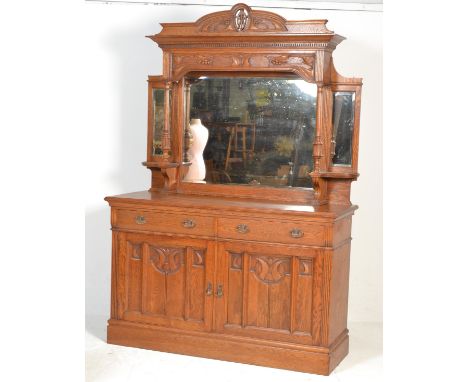 A late Victorian oak Arts and Crafts mirror backed sideboard the upper section comprising central mirror flanked by two furth