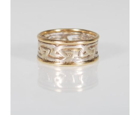 A stamped 375 9ct gold two tone ring having a pierced decoration celtic knot design in white gold with yellow gold borders. W