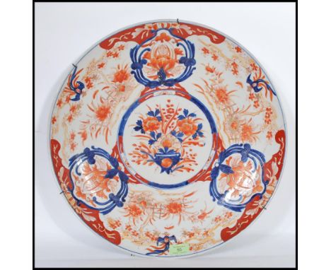 A large 18th /19th Century Chinese export Imari pattern charger decorated with bold vase of flowers and floral and hatched bo