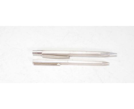 Two silver hallmarked pens having engine turned decoration #, one having a twist mechanism and the other a button mechanism. 