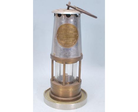 A mid 20th Century brass Eccles miners lamp embossed brass plaque reading 'Protector Lamp &amp; Lighting No. 1A Eccles, Manch