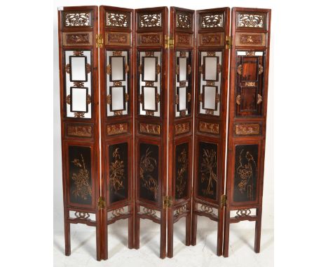 A large 20th Century six fold Chinese lacquered pine screen having scroll fret work panel atop with carved flower and butterf