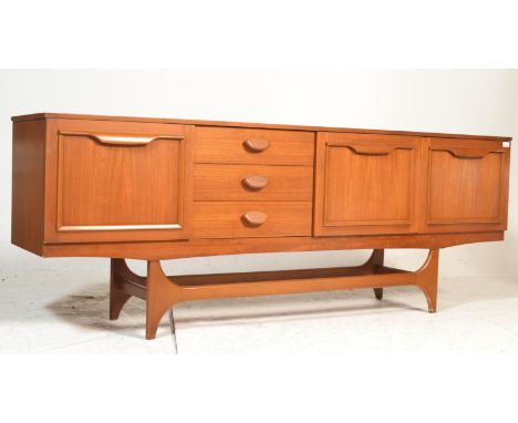 An original retro vintage mid-century teak wood sideboard credenza. Raised on shaped&nbsp; legs with pierced stretchers suppo