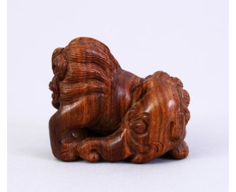 A JAPANESE MEIJI PERIOD STYLE CARVED WOODEN NETSUKE OF A LION ELEPHANT, the lion dog with an elephants head, signed to foot, 
