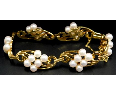 A cultured pearl bracelet, design of gold scrolls each bearing six cultured pearls, yellow metal, marked K18, with safety cha