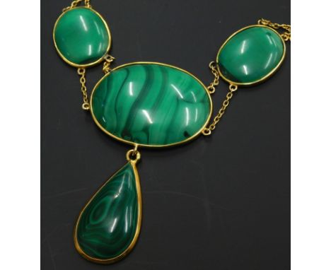 A malachite necklace, set with four malachite stones, three of oval form, together with one of tear drop form, creating a dro