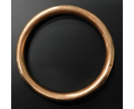 A Victorian rose metal hollow bangle, unmarked.  
