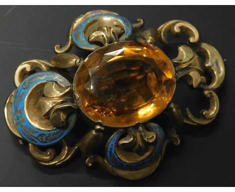 A Victorian enamel and citrine brooch, in a gilt metal frame, with one section of enamel missing (AF), 7cm wide. 