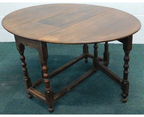 An 18thC oak drop leaf gate leg dining table, on turned supports, united by cross stretchers, 104cm wide.