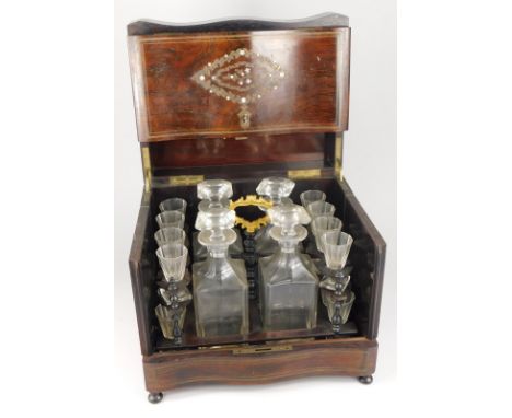 A late 19thC French rosewood, brass and mother of pearl inlaid drinks cabinet, the hinged lid enclosing four decanters and si