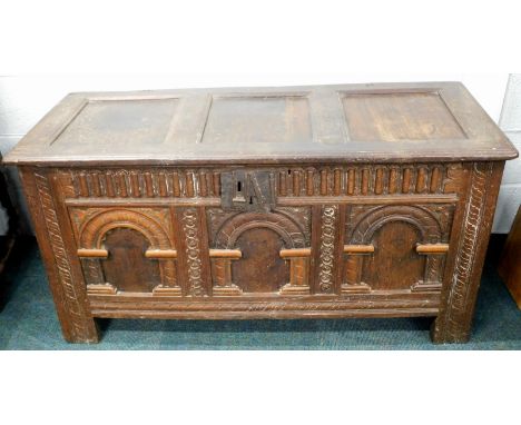 An 18thC carved oak coffer, with three panel plain top and three fielded relief panels to the front, 135cm wide.