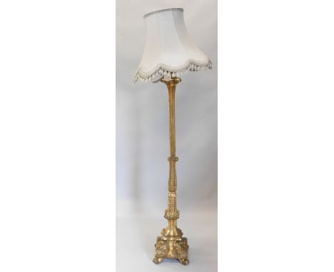 A Continental gilt wood standard lamp, with reeded leaf carved column on a square base with scroll feet, including shade, 184
