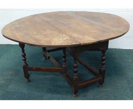 An 18thC oak drop leaf gate leg dining table, on turned supports united by cross stretchers, 138cm wide.