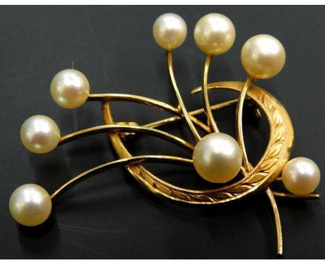A cultured pearl brooch, with one fern leaf wrapped around a bouquet of flowers, each with pearl to end, yellow metal, marked