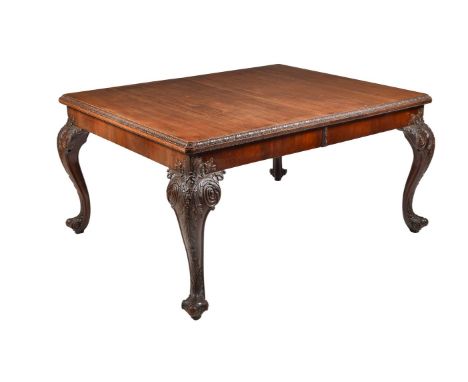 A mahogany extending dining table, circa 1920, with leaf carved moulding and four richly carved cabriole legs, includes three