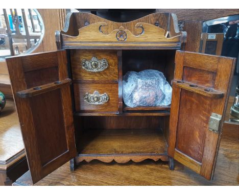 An Edwardian carved oak smoker's cabinet with original tobacco jar 