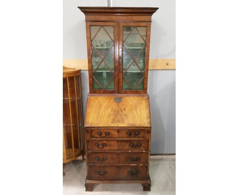 A narrow early 20th century crossbanding figured mahogany bureau bookcase in the Georgian style, the upper section with 2 gla