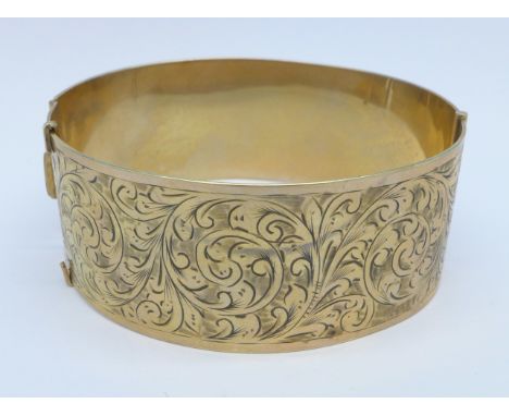 A 9ct gold and metal core bangle