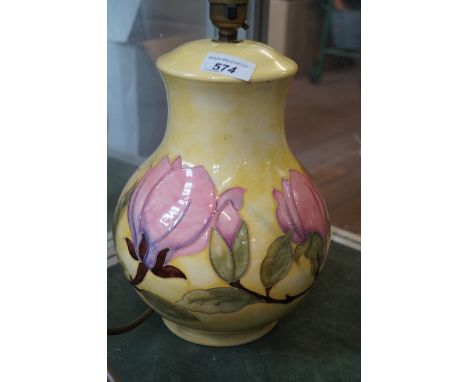 A Moorcroft Pottery Magnolia pattern baluster form lamp decorated upon a yellow ground.