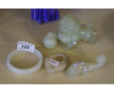 Four pieces of Chinese hardstone to include a model of a shishi lion, bangle etc.