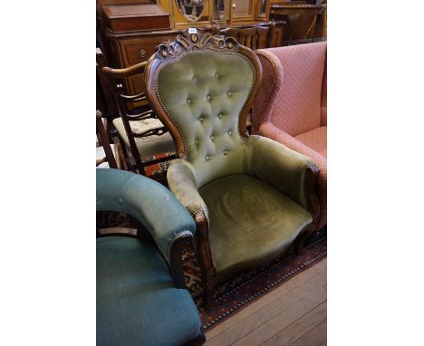 A reproduction Victorian style button back armchair upholstered in a green material.