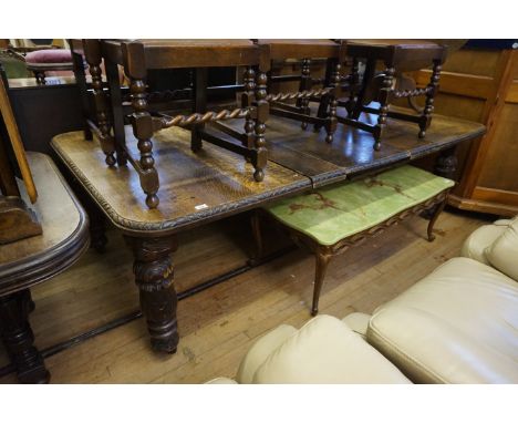A Victorian carved oak wind action extending dining table, the rectangular top with rounded corners and drop-in leaves, above
