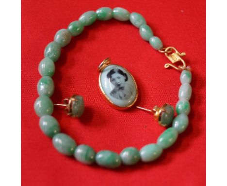 A jadeite jade bead bracelet, the clasp stamped 916, together with, a pair of jadeite ear studs and a pendant (3)