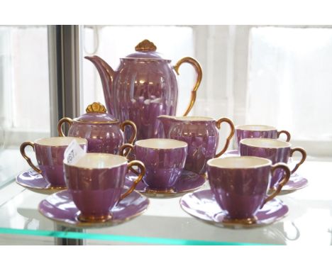 A Carltonware pink lustre tea set comprising six cups and saucers, sugar bowl, milk jug and coffee pot.