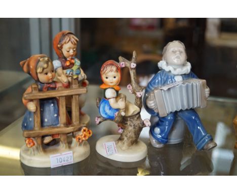 A Royal Copenhagen ceramic model of a boy playing musical instruments, together with three Goebel Hummel figures to include a