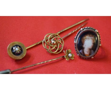 Three yellow metal stick pins, unmarked, with various designs and pearl detail, together with, a ceramic painted portrait rin