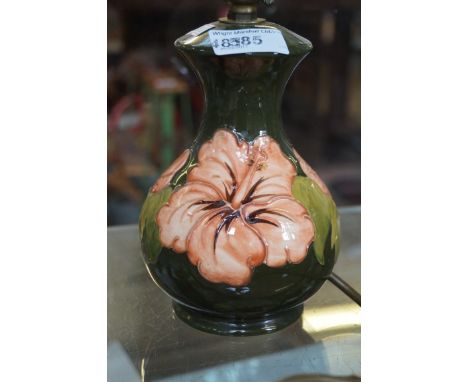 A Moorcroft Pottery Hibscus pattern lamp base decorated upon a green ground.