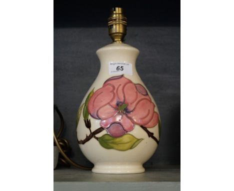 A Moorcroft Pottery table lamp decorated in the Magnolia pattern on ivory ground.