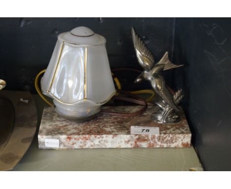 An Art Deco desk lamp modelled with a bronzed spelter swallow beside glass shade.