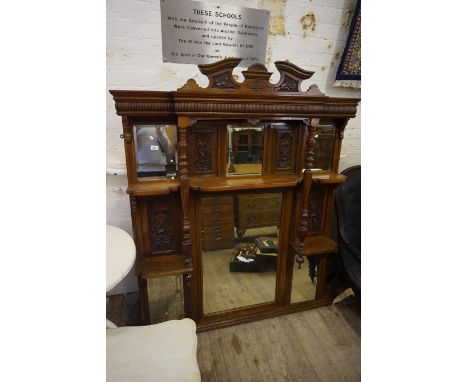A late Victorian mahogany over mantel mirror having carved sectional panels and mirrored plates.