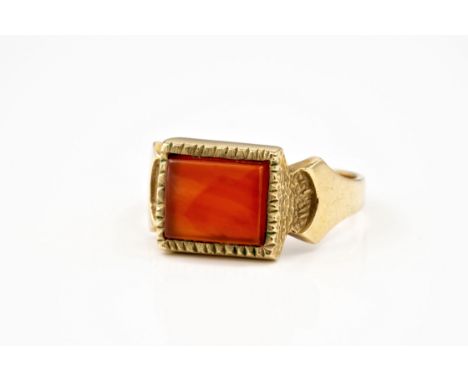 A 9ct yellow gold and carnelian ring, hallmarked London 1970, the rectangular slightly domed carnelian within a notched borde